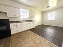 Well-lit kitchen with white cabinets, modern appliances, and two-toned flooring at 1509 S Rural St, Indianapolis, IN 46203