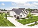 Aerial view of a two-story home with a manicured lawn and long driveway at 16283 Spring Bank Ct, Fishers, IN 46040