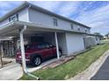 Exterior view showcasing a covered carport area with a red car parked inside at 2080 Miracle Dr, Columbus, IN 47201