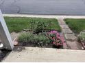 Flower garden with lush greenery and colorful blooms in the front yard at 2080 Miracle Dr, Columbus, IN 47201
