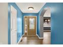Inviting entryway featuring wood-look floors, light brown front door and light-filled archway to the kitchen at 248 Eastview Dr, Bargersville, IN 46106