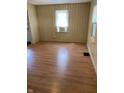 A bright living room with wood paneling, wood-look floors, and ample natural light from two windows at 3059 5Th E Ave, Indianapolis, IN 46221