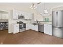 Modern kitchen with stainless steel appliances, white cabinets, and stylish lighting. Laundry in background at 421 E Delaware St, Fortville, IN 46040