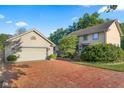 Lovely two-story house with a detached garage, brick driveway, and lush greenery at 4224 River Rd, Columbus, IN 47203
