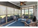 Cozy sunroom featuring wicker furniture, a blue carpet, and natural light from the surrounding windows at 4905 Lilium Dr, Plainfield, IN 46168