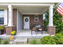 Cozy front porch with seating area, plants, and a decorative wreath on the front door at 6137 Hardwick Dr, Whitestown, IN 46075