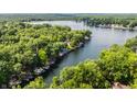 An aerial view of a lakefront community, featuring beautiful landscaping and mature trees along the waterfront properties at 7082 Muskrat Dr, Nineveh, IN 46164