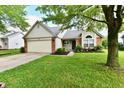 Cozy single-level home with a green lawn, attached garage, and decorative landscaping enhancing curb appeal at 10548 Magenta Dr, Noblesville, IN 46060