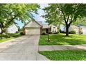 Inviting single-story home with a well-kept lawn, attached garage, and mature trees in a residential neighborhood at 10548 Magenta Dr, Noblesville, IN 46060