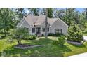 Charming stone home with a well-manicured lawn and beautiful landscaping at 10585 Golden Bear Way, Noblesville, IN 46060