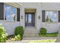 A welcoming front entrance featuring stone siding, a glass front door, and beautiful sconces at 10585 Golden Bear Way, Noblesville, IN 46060