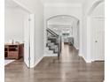Open foyer with hardwood floors, staircase, and arched doorways leading to other rooms at 10795 Creekbed Cir, Fishers, IN 46038
