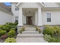 Inviting front porch with stone accents and colorful potted plants at 10795 Creekbed Cir, Fishers, IN 46038