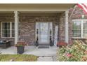 Inviting front porch with decorative plants and patriotic accents around the doorway at 1202 Vestman Ct, Greenwood, IN 46143