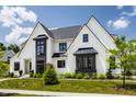 Beautiful home exterior with black trim, white brick, and vibrant landscaping, perfect for curb appeal at 12022 Otto Ln, Carmel, IN 46032