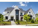 Gorgeous white brick home with dark trim, professional landscaping, and a welcoming front walkway at 12022 Otto Ln, Carmel, IN 46032