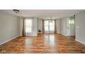 Sun-filled living room with hardwood floors and neutral paint, enhanced by natural light from large windows at 124 Bess Blvd, Pendleton, IN 46064