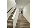 Bright hallway showcasing hardwood flooring leading to a carpeted staircase and naturally lit rooms at 1248 Cassine Pl, Greenwood, IN 46143