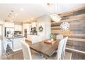 Elegant dining room featuring a rustic accent wall and modern chandelier at 12838 Bird Cage, Carmel, IN 46032