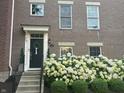 Inviting townhouse entrance with black door, decorative wreath, and neatly landscaped flowerbed at 12838 Bird Cage, Carmel, IN 46032