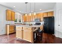 Well-lit kitchen features stainless steel appliances, hardwood floors, and a center island with seating at 143 W Clear Lake Ct, Westfield, IN 46074