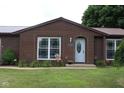 Charming brick home entrance featuring a well-maintained lawn and classic white front door at 1504 Gwinn Ln, Lapel, IN 46051