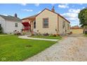 Cozy bungalow featuring a green lawn, rock driveway, and a delightful red porch swing at 2017 E Legrande Ave, Indianapolis, IN 46203