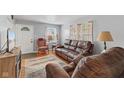 Comfortable living room with a brown leather sofa, chair, area rug, and plenty of natural light at 2017 E Legrande Ave, Indianapolis, IN 46203