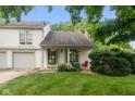 Charming two-story home features a covered front porch, stone chimney, and well-maintained landscaping at 2578 Chaseway Ct, Indianapolis, IN 46268