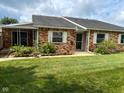 Charming brick townhome featuring a covered front porch and a well-maintained lawn at 2770 Two Worlds Dr, Columbus, IN 47201