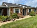 Charming brick townhome featuring a covered front porch and a well-maintained lawn at 2770 Two Worlds Dr, Columbus, IN 47201