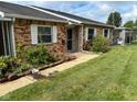 Charming brick townhome featuring a covered front porch and a well-maintained lawn at 2770 Two Worlds Dr, Columbus, IN 47201