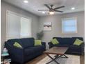 Comfortable living room with two navy blue sofas, green pillows, a ceiling fan, and natural light at 2822 Tindall St, Indianapolis, IN 46203
