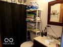 Compact bathroom with a toilet, sink, mirror, and shower curtain, providing basic amenities at 3213 S Cherokee Rd, Muncie, IN 47302