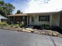 Charming brick ranch home with decorative shutters and lush landscaping surrounding the front entrance at 4675 N Riverside Dr, Columbus, IN 47203