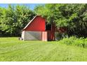 Classic red barn features white trim, an open doorway, and ample storage space at 4765 E 200 N, Anderson, IN 46012