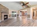 Spacious living room features wood flooring, a brick fireplace, and sliding glass doors for natural light at 505 E Marion Ave, Arcadia, IN 46030