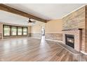 Open living room featuring a brick fireplace, wood beam, and windows offering great natural light at 505 E Marion Ave, Arcadia, IN 46030