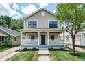 Charming two-story home with a covered front porch and a well-maintained lawn at 5930 Broadway St, Indianapolis, IN 46220