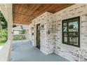 Charming front porch featuring whitewashed brick, wood ceiling, and stylish lighting fixtures at 5930 Broadway St, Indianapolis, IN 46220