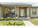 Inviting covered front porch with seating area, decorative plants, and 'Welcome' sign at 6102 Boulder Dr, Anderson, IN 46013