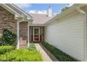 Inviting front entrance with red door, brick accents, and manicured landscaping at 6928 Shoals Way, Indianapolis, IN 46237