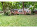 A well-maintained lawn and garden accentuate this charming brick home at 7224 N Tuxedo St, Indianapolis, IN 46240