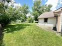 Large backyard with a well-kept lawn and partial view of neighborhood pond at 7450 Cobblestone W Dr, Indianapolis, IN 46236