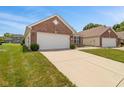 A view of a single-story home with an attached two-car garage and a driveway at 882 Lincoln Park W Dr, Greenwood, IN 46142