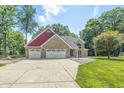 Charming brick home features a three-car garage and a well-maintained front yard with mature trees at 1066 N Dogwood Way, Greenfield, IN 46140