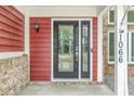 The front door is accented with decorative glass inserts and stylish black hardware and side light at 1066 N Dogwood Way, Greenfield, IN 46140