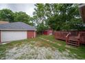 Spacious backyard featuring a detached garage, a storage shed, a lawn, and a wooden deck at 11218 Exchange St, Indianapolis, IN 46259