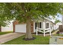 Attractive home featuring brick accents, vinyl siding, green grass and a tree in the front yard at 11620 Glenn Abbey Ln, Indianapolis, IN 46235