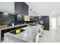 Modern kitchen with a large island, black cabinets, and stainless steel appliances at 1324 E 9Th, Indianapolis, IN 46202
